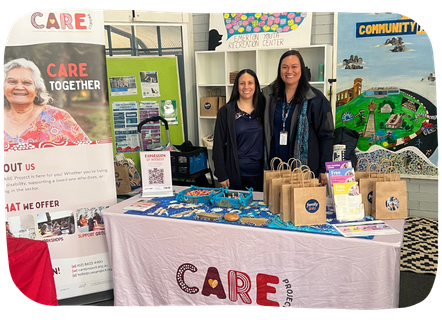 CARE Project team member chatting with a family at a community information stall.